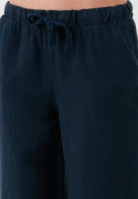 Navyblauwe linnen mix broek met een elastische tailleband en een trekkoord. De stof heeft een zachte textuur en een ontspannen pasvorm.