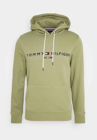 Hellgrüner Hoodie mit Fronttasche, weißen Kordeln und dem Schriftzug "Tommy Hilfiger Est. 1985" über der Brust mit Logodetail.