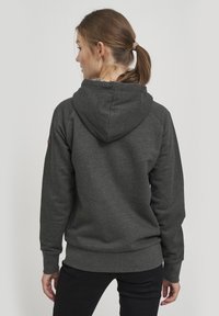 Felpa con cappuccio di un grigio scuro con finitura testurizzata, caratterizzata da un design a maniche raglan e polsini e bordo a coste. Nessun marchio visibile.