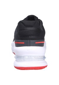Zapatilla deportiva negra con parte superior texturizada, acentos rojos, suela blanca acolchada y unidad de aire visible en el talón. Diseñada para comodidad y soporte.