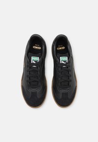 Svarta sneakers med en slät läderöverdel, suède-accenter, gummigummisula och snördesign. PUMA-logotyp och retro-grafik ingår.