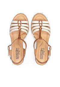 Sandalias con tiras en piel blanca y marrón, con correas en el tobillo ajustables y una suela de estilo espadrille tejida con una textura suave.