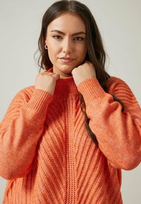 Helle orange gestrickte Pullover mit Rippstruktur, hohem Kragen und langen Ärmeln. Verfügt über ein Zickzackmuster und eine lässige Passform.