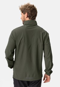Veste imperméable vert olive avec un col haut, des manches longues, des poignets élastiques et un panneau de ventilation arrière. Accents réfléchissants présents.
