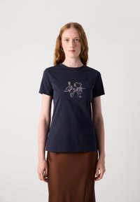 Navy blue t-shirt made of cotton with short sleeves, featuring a textured graphic design that reads "LO 3GOS" in metallic accents.