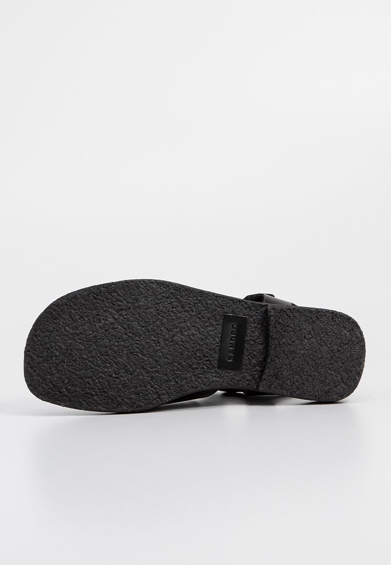 Zwarte sandaalzool van gestructureerd rubber, met een gebogen vorm en een lichte hak. De zool is ontworpen voor grip en duurzaamheid.