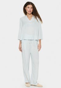 Set di abbigliamento comodo leggero a righe in blu e giallo. La parte superiore ha un collo a V e maniche a campana, mentre i pantaloni presentano una vita elastica.