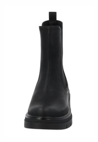 Botín de cuero negro con acabado liso, paneles laterales elásticos, una lengüeta para facilitar el calzado y una suela gruesa de goma, con diseño de punta redondeada.