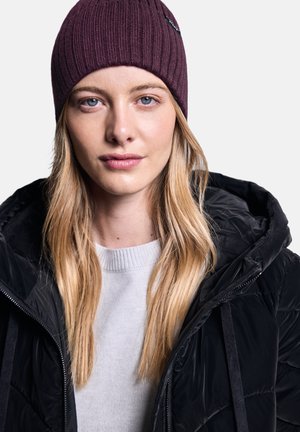 Maroon geribbelde beanie, grijze sweater met een ronde halslijn, en een zwarte pufferjack met rits en capuchon. Gladde texturen en gelaagd uiterlijk.