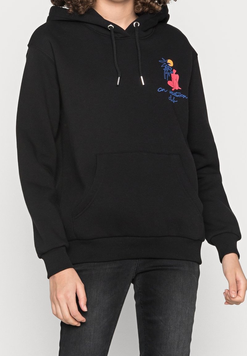 Černá mikina s kapucí, přední kapsou a šňůrkami, s grafickým designem znázorňujícím palmy a postavu s textem "na dovolené."