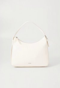 Τσάντα χειρός από κρεμ δέρμα με καμπυλωτό σχήμα, έναν ιμάντα ώμου, επάνω φερμουάρ και διακριτική σήμανση στο μπροστινό μέρος.