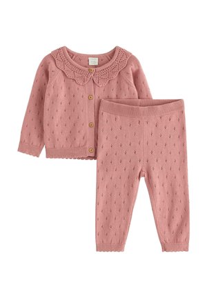 Tenue de bébé tricotée rose avec cardigan à col festonné et pantalon assorti, avec un petit motif ajouré et des boutons en bois sur le cardigan.