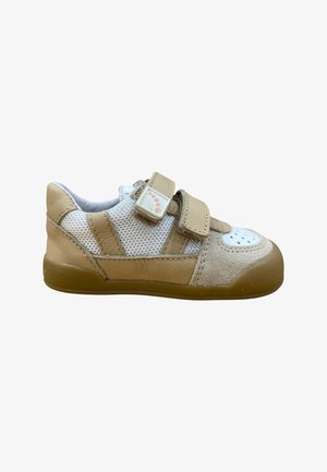 Zapato para niño pequeño en beige y blanco con paneles de malla, dos tiras ajustables de velcro, área delantera perforada y suela de goma marrón.