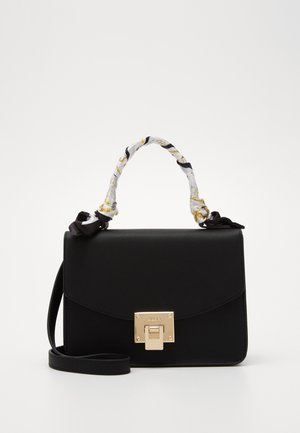 Sac à main rectangulaire noir avec fermoir doré, poignée supérieure enveloppée de tissu blanc et doré, et longue bandoulière noire.