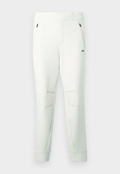 Λευκό φούτερ παντελόνι από απαλό ύφασμα, με δύο τσέπες με φερμουάρ, διακοσμητικές ραφές και ριμπ μανσέτες για εφαρμοστή εμφάνιση.