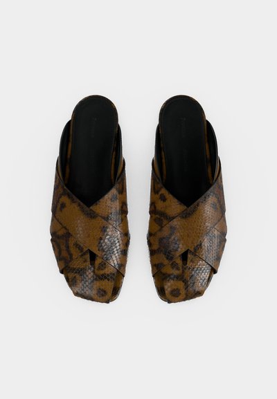 Paire de sandales marron à enfiler avec imprimé serpent, brides croisées et semelles intérieures noires rembourrées sur fond blanc uni.