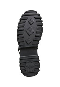 Zwarte rubberen zool met een gestructureerd oppervlak, diepe groeven en een cirkelvormig logo. Verschillende diamante patronen zijn zichtbaar voor extra grip.