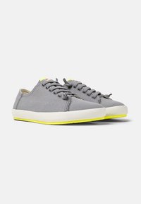 Gray canvas sneakers with a round toe, featuring a white sole accented with bright yellow. Laces and eyelets match the sneaker color.