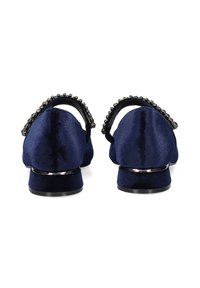 Bailarinas de terciopelo azul marino con un tacón bajo, que presentan una correa negra decorada con cuentas en la parte trasera. Textura suave y forma clásica.