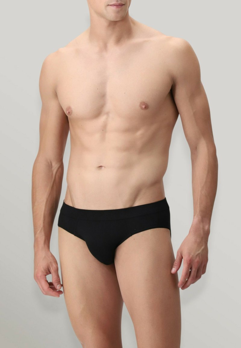 Completo intimo nero caratterizzato da un tessuto liscio, design a vita bassa e una cintura elastica minimalista. Senza motivi o accenti aggiuntivi.