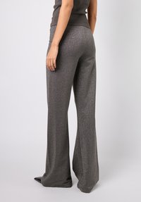 Høytlivede, utsvingte bukser i mørkegrått stoff med metallisk skimrende mønster, med en jevn overflate og vide, flytende ben.