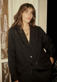 Schwarzer Blazer mit strukturiertem Design, der dezente sternförmige Verzierungen, einen Einzelknopfverschluss und Vordertaschen aufweist.