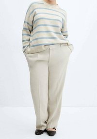 Maglione beige a righe con linee orizzontali azzurro chiaro, abbinato a pantaloni su misura color crema. Tessuto morbido, vestibilità rilassata e tasche laterali.