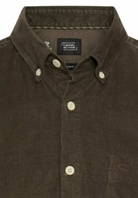 Brązowa koszula z sztruksu z kołnierzykiem zapinanym na guziki, z białymi guzikami i subtelnym logo blisko kieszeni. Teksturowana tkanina z pionowymi prążkami.