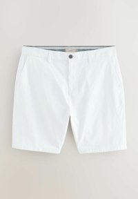 Los pantalones cortos de algodón blancos cuentan con un cierre de botón y dos bolsillos laterales. Tienen una textura suave y un corte sencillo.