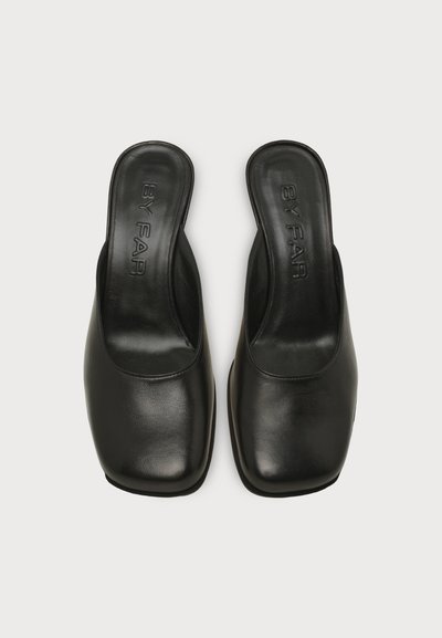 Paire de chaussures en cuir noir à enfiler avec bouts carrés et "BY FAR" embossé sur les semelles intérieures, vues de dessus sur fond blanc.