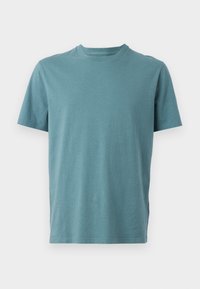 T-shirt de algodão em teal com decote redondo, mangas curtas e um corte descontraído. Textura suave sem padrões ou elementos em destaque visíveis.