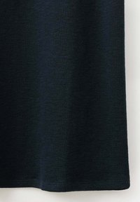 Gros plan d'un tissu côtelé noir foncé avec une texture verticale et un ourlet cousu en bas du textile.