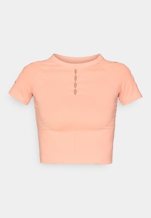 Korte mouwen cropped top van zacht perzikkleurig materiaal, met een hoge kraag en een rij van vijf uitsparingen aan de voorkant. Gladde textuur, aansluitend ontwerp.