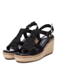 Sandali wedge neri con cinturini in tessuto intrecciato, un accento di corda rotondo e una suola intermedia avvolta in juta. Soletta in pelle liscia e cinturino alla caviglia.