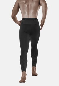 Zwarte leggings met een aansluitend ontwerp en diamantpatroonaccenten bij de enkels. Bevat een ritspocket op de achterkant van de taille.