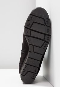 Czarny zamszowy sneaker z teksturowaną gumową podeszwą z bieżnikiem. Rozmiar 37 jest wytłoczony na podeszwie. Minimalistyczny design.