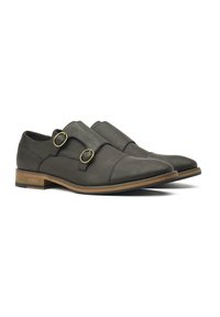 Dark grey leather shoes with dual buckle accents, pointed toe design, and a tan rubber sole, featuring a smooth texture and minimal stitching.