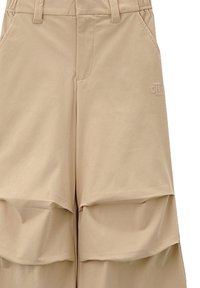 Pantaloni casual marrone chiaro con dettagli in tessuto stratificato sulla parte anteriore delle cosce e un piccolo logo CK ricamato sul lato destro.