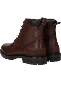 Bottines en cuir marron avec une finition texturée, talon noir et accents, bout rond et semelle en caoutchouc robuste avec des motifs de traction.