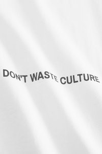 White cotton t-shirt featuring bold black text that reads "DON'T WASTE CULTURE" across the front. Smooth texture and standard fit.