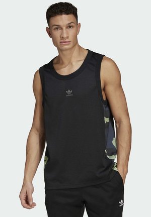 Canottiera atletica nera senza maniche con texture a rete, caratterizzata da un motivo camouflage sui lati e un piccolo logo Adidas grigio sulla parte anteriore.
