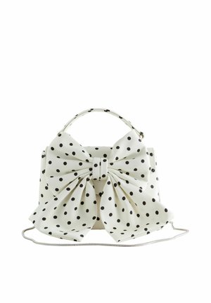 Sac à main blanc à pois noirs, grand nœud assorti à l'avant, poignée supérieure et fine bandoulière argentée.
