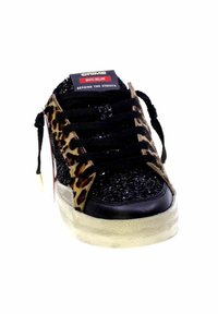 Scarpa da skate nera con lati in stampa leopardata, tomaia testurizzata con glitter, lacci neri e una suola in gomma bianca, leggermente rialzata.