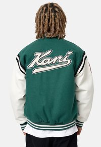 Giacca varsity verde e bianca con un grande logo "Kani" sul retro, con accenti a righe sulle maniche e polsini e orlo a costine.