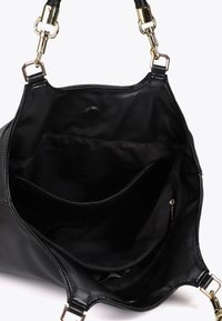 Černá kožená kabelka otevřená, ukazující vnitřní oddíly a zipy. Popruhy se zlatými sponami jsou viditelné na horních okrajích.