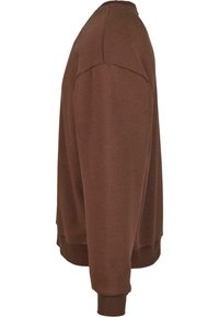 Sudadera de cuello redondo marrón con mangas largas. La tela parece suave y texturizada, con puños y dobladillo acanalados para un ajuste ceñido.