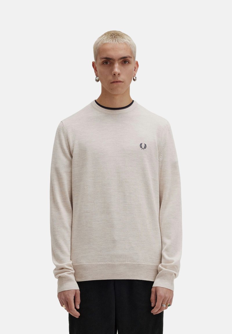 Suéter de manga larga color beige claro en un suave material de punto, con un cuello y puños acanalados, y un pequeño logo bordado en el pecho.