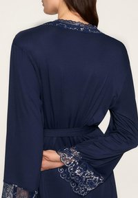 Granatowy szlafrok z długimi rękawami, ozdobiony koronkowymi akcentami i pasującym paskiem, wykonany z gładkiego materiału o swobodnym kroju.