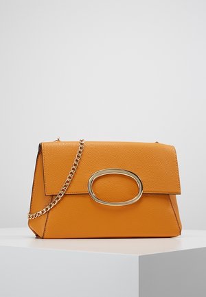 Sac à main en cuir orange vif avec une finition texturée, doté d'un rabat avant, d'une grande fermeture ovale et d'une bandoulière en chaîne dorée.