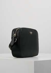 Schwarze, geprägte Leder-Crossbody-Tasche in rechteckiger Form, mit goldener Hardware und Reißverschluss. Inklusive verstellbarem Tragegurt.